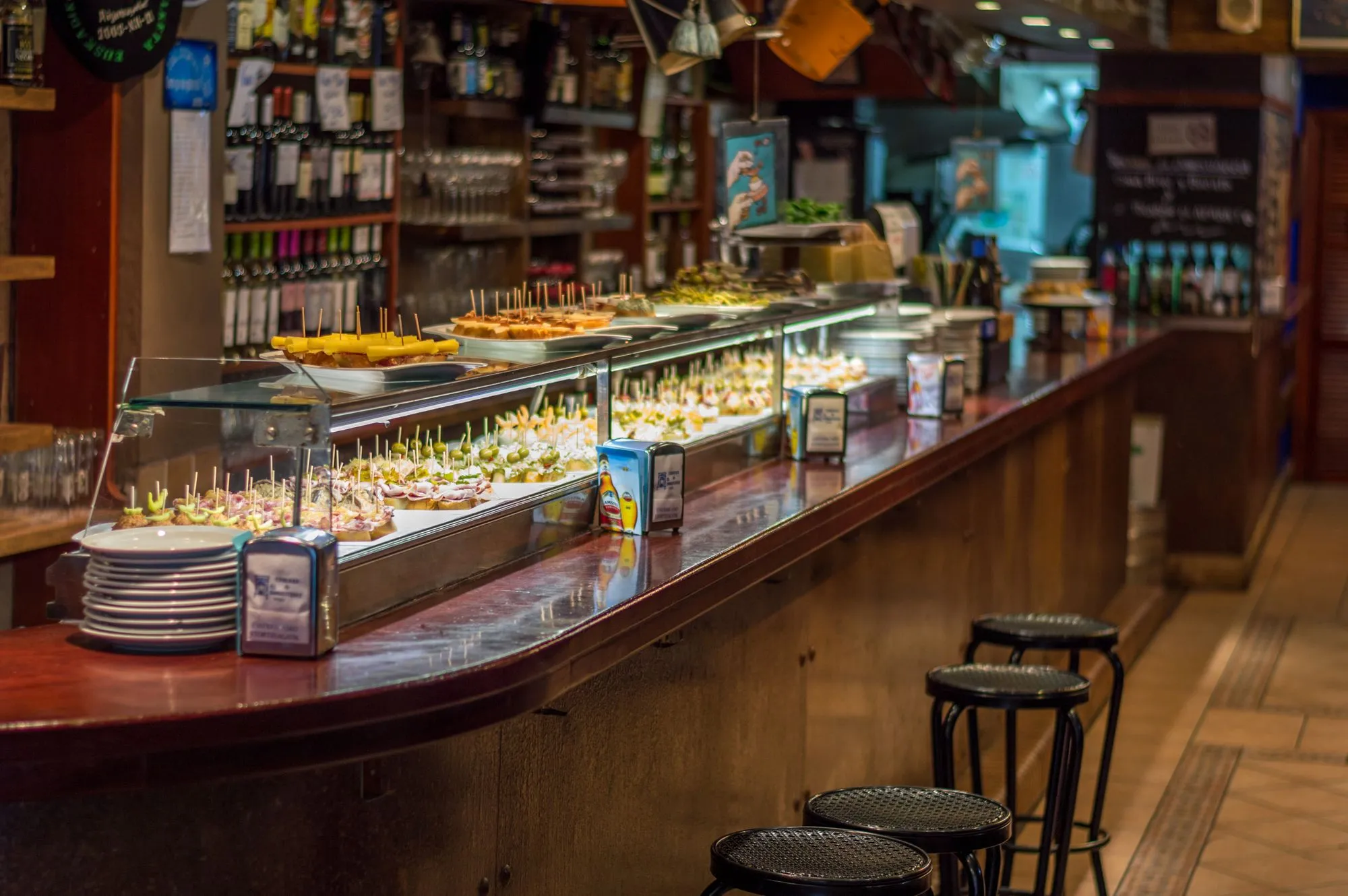 Barra de un bar de pintxos llena de raciones